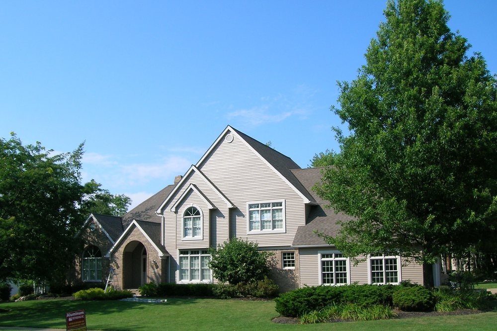 Cream Tudor-style home refinished with clean trim