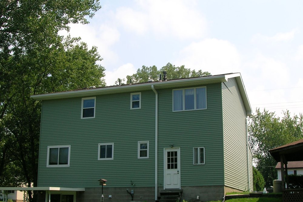 Green two-story home refinished in a fresh, even finish