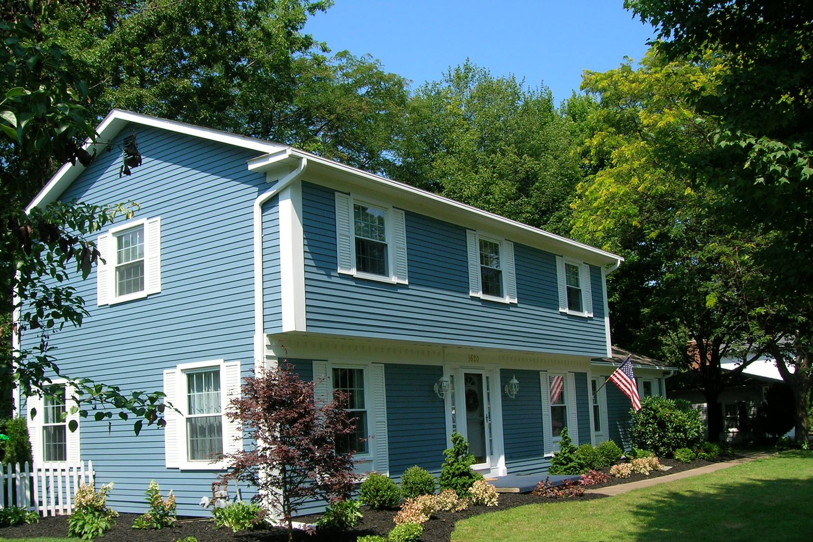 An Erie home with freshly refinished aluminum siding in a rich blue finish